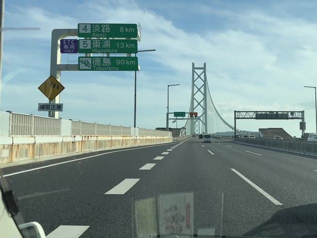 車内から見た明石海峡大橋。案内標識に淡路 8km